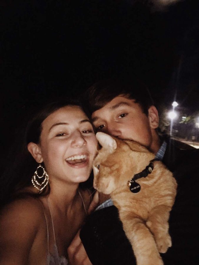 Chloe+and+Caden+hold+our+local+CHS+cat+and+snap+a+picture+on+Homecoming+night.