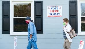 Voters wait in line to cast their ballots on Election Day, 2020