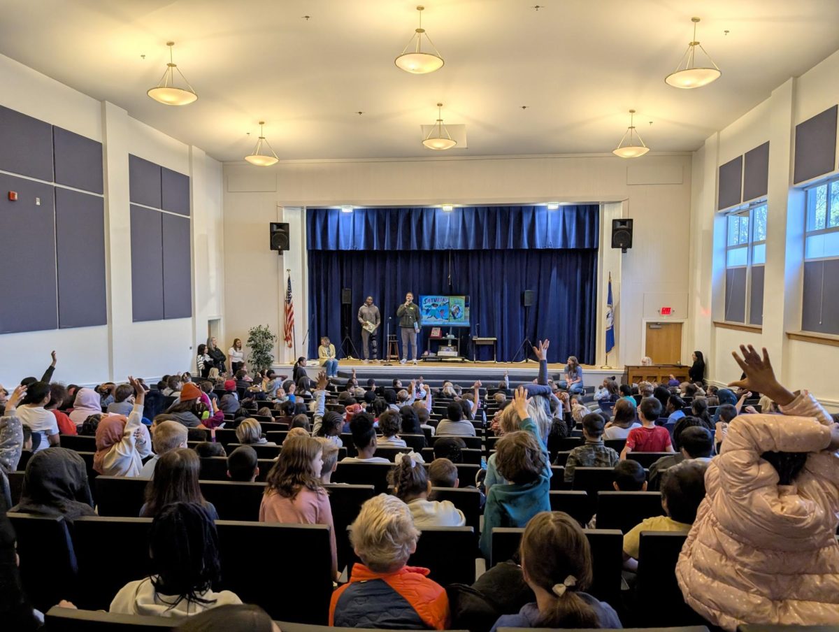 Joe Reed [left] and Chris Long [right], answering questions from Johnson Elementary School students at their morning assembly on Friday, December 6th. (Photo courtesy of the Chris Long Foundation).
