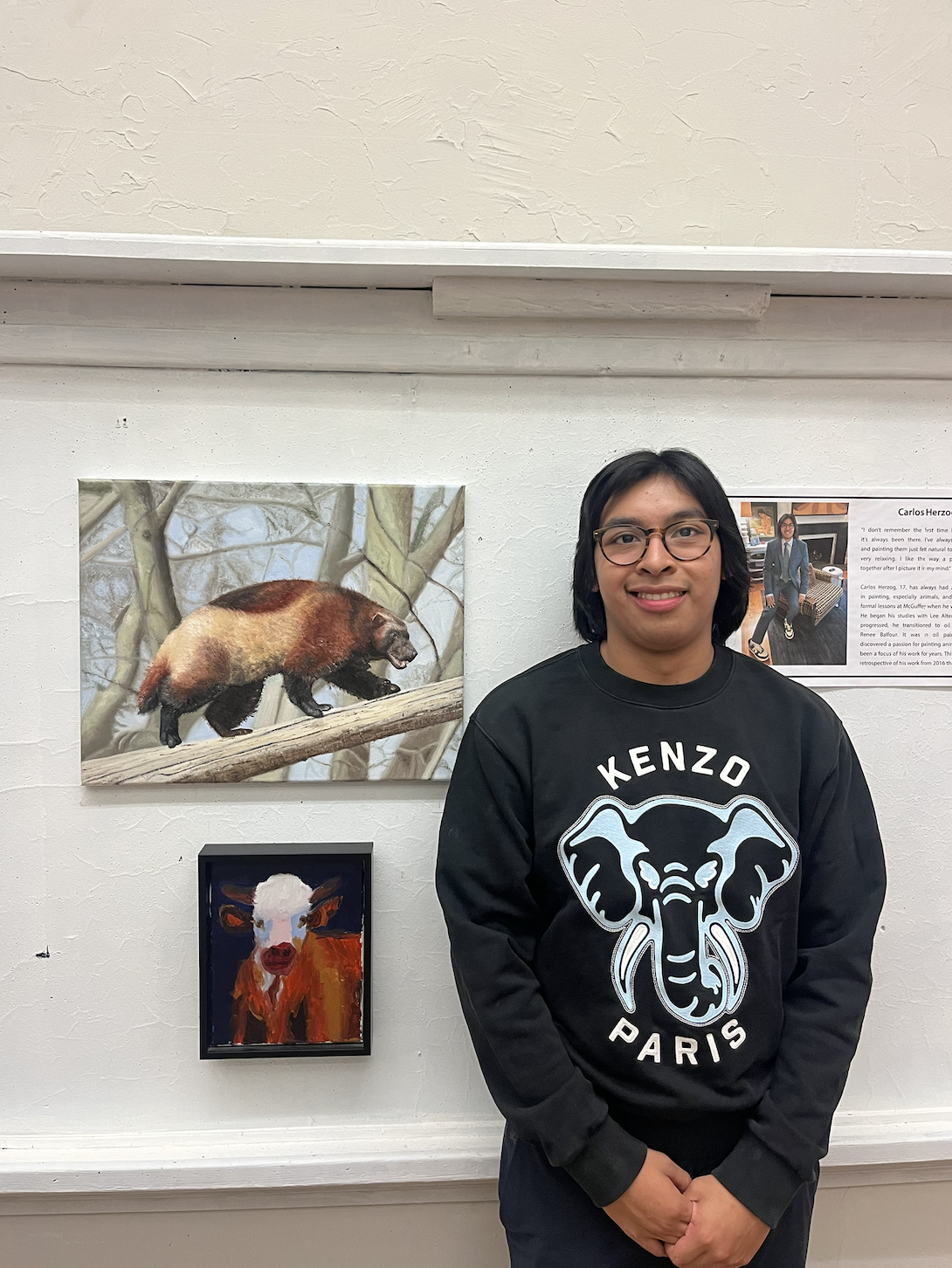 Carlos Herzog next to two of his own paintings.